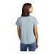 A woman wearing a light blue AllMade t-shirt with a scoop neck.