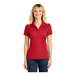 A woman wearing a red Sport-Tek short sleeve polo shirt.