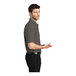 A man wearing a medium Port Authority® charcoal heather gray short sleeve polo shirt.