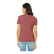 A woman wearing a Bella + Canvas heather mauve customizable short sleeve t-shirt.