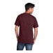 A man wearing a maroon Port & Company short sleeve T-shirt.