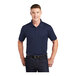 A man wearing a navy Sport-Tek moisture-wicking polo shirt.