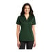 A woman wearing a dark green Port Authority silk touch polo shirt.