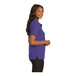 A woman wearing a purple Port Authority polo shirt.