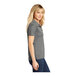 A woman wearing a Sport-Tek concrete grey polo shirt.