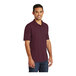 A man wearing a maroon Port & Company jersey knit polo shirt.