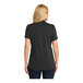 A woman wearing a black Port Authority Dry Zone polo shirt with a v-neck.