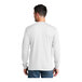 A man wearing a white Port & Company long sleeve t-shirt.