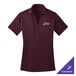 A maroon Port Authority women's polo shirt with a logo on it.