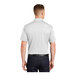 A man wearing a white Sport-Tek short sleeve polo shirt.