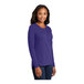 A woman wearing a purple Port & Company long sleeve shirt.