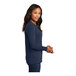 A woman wearing a navy Port & Company long sleeve t-shirt.