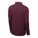 A Sport-Tek unisex maroon long sleeve polo shirt on a mannequin.