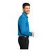 A man wearing a Port Authority Brilliant Blue Silk Touch long sleeve polo.