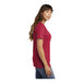 A woman wearing a red Port & Company short sleeve t-shirt with a pocket.