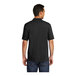 A man wearing a Port & Company jet black jersey knit polo shirt.
