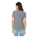 A woman wearing an athletic heather Bella + Canvas customizable short sleeve t-shirt.