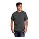 A man smiling in a coal gray Port & Company short sleeve T-shirt.