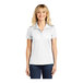 A woman wearing a white Sport-Tek short sleeve polo shirt.