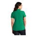 A woman wearing a bright kelly green Port Authority polo shirt.