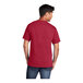 A man wearing a red Port & Company classic unisex T-shirt.