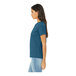 A woman wearing a heather deep teal Bella + Canvas short sleeve t-shirt.