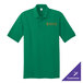 A green Port & Company polo shirt with a school logo in orange.