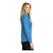 A close-up of a Port Authority women's long sleeve blue polo shirt.