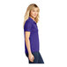 A woman wearing a purple Sport-Tek short sleeve polo shirt.