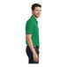 A man wearing a Port Authority bright kelly green short sleeve polo shirt.