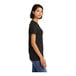 A close-up of a woman wearing a black District combed ring-spun cotton T-shirt.