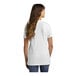 A woman with long hair from the back wearing a white Port & Company short sleeve t-shirt.