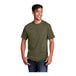 A man smiling and wearing an olive drab green Port & Company cotton t-shirt.