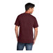 A man wearing a maroon Port & Company short sleeve t-shirt.