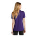 A woman wearing a purple Nike Court polo shirt.