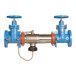 A blue Watts reduced pressure zone assembly with two orange NRS shutoff valves.