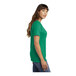 A woman wearing a green Port & Company v-neck t-shirt.