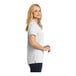 A woman wearing a white Port Authority Dry Zone short sleeve polo shirt.