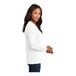 A woman wearing a white Port & Company long sleeve T-shirt.