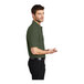 A man wearing a clover green Port Authority silk touch pique polo shirt.