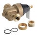 A Watts brass water pressure reducing valve with brass fittings on a black pipe.
