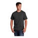 A man smiling and wearing a Port & Company black heather short sleeve T-shirt.