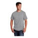 A man smiling and wearing a Port & Company athletic heather short sleeve t-shirt in grey.