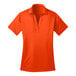 A Port Authority women's orange polo shirt with a collar and short sleeves.