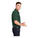 A man wearing a forest green Sport-Tek short sleeve polo.