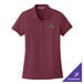 A Port Authority women's maroon polo shirt with a logo on it.