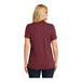 A woman wearing a Port Authority Dry Zone women's burgundy short sleeve polo shirt.