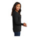 A woman wearing a black Port & Company long sleeve t-shirt.