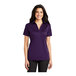A woman wearing a Port Authority bright purple short sleeve polo shirt.