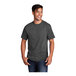 A man smiling and wearing a dark heather gray Port & Company short sleeve T-shirt.